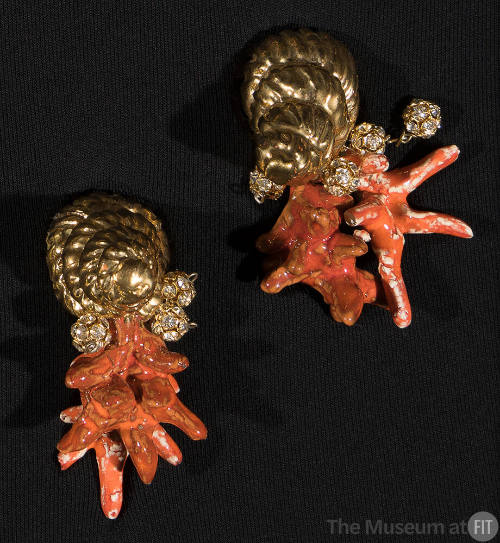 Pair of gold metal earrings in the shape of spiral seashells with attached clusters of orange/r…
