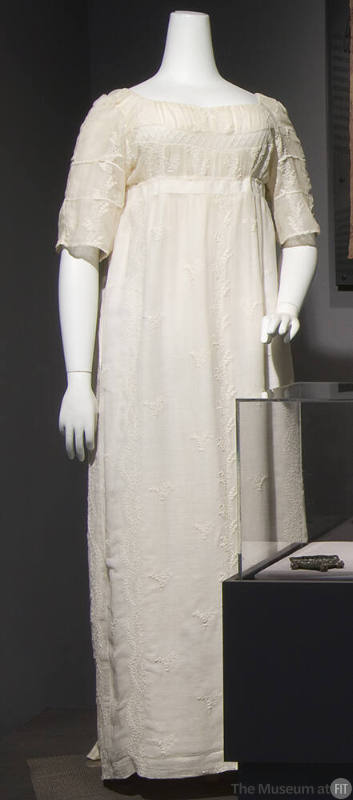 White cotton gauze floor length dress with empire waist, elbow length sleeves and embroidery th…
