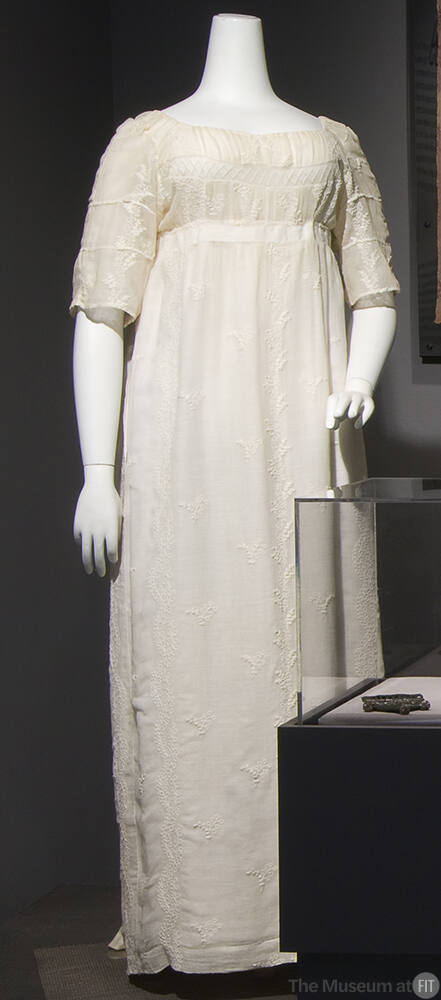 White cotton gauze floor length dress with empire waist, elbow length sleeves and embroidery th…