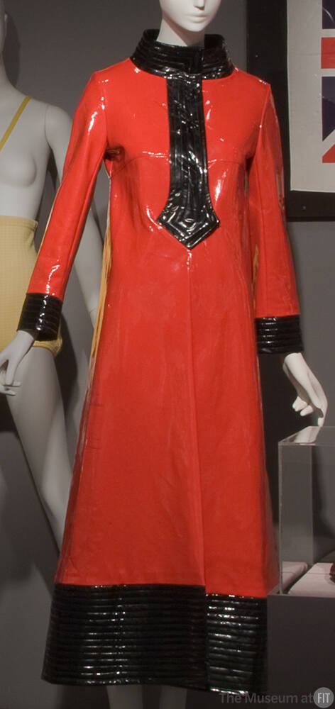 Red vinyl ankle length raincoat with black stand collar, stylized pointed placket, cuffs and he…