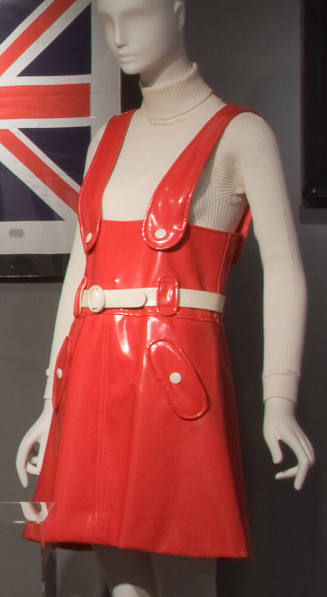 Red vinyl jumper mini dress with white belt, white buttons on wide shoulder straps and on hip p…
