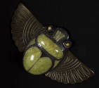 Green and black scarab pendant with outstretched tan celluloid wings and yellow eyes