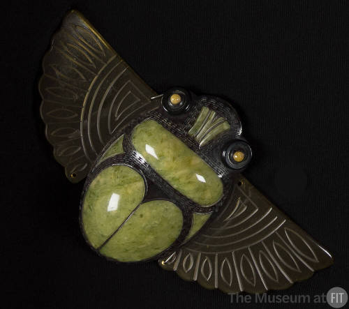 Green and black scarab pendant with outstretched tan celluloid wings and yellow eyes
