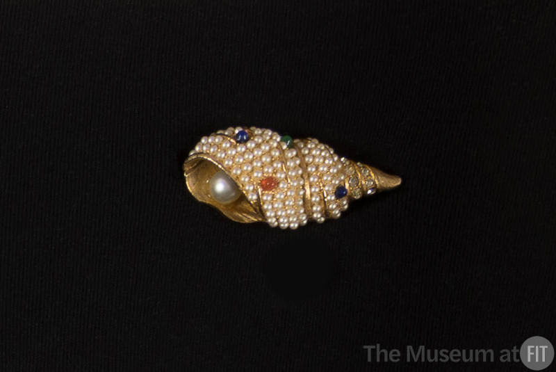 Gold brooch in the shape of a tulip shell covered in seed pearls, rhinestones, and blue, green …
