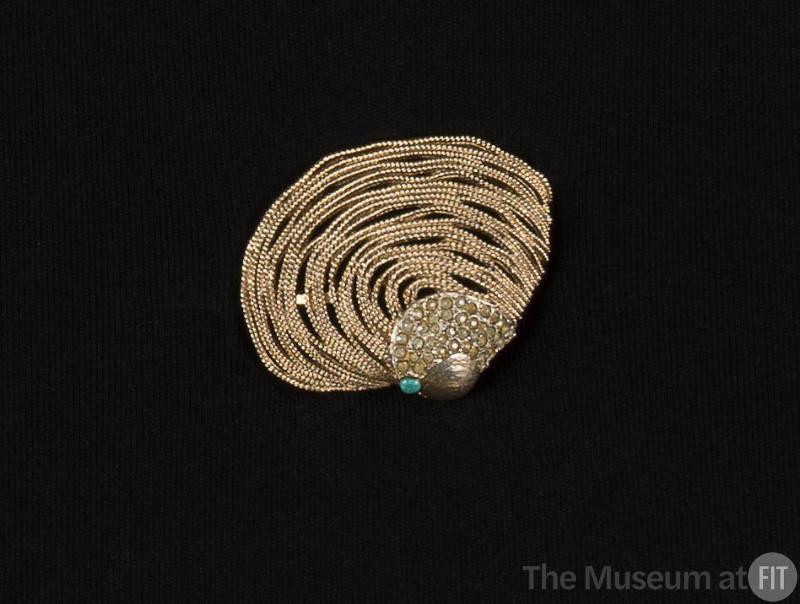 Gold brooch made into the shape of a clamshell with multiple strands of chain with rhinestones …