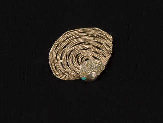 Gold brooch made into the shape of a clamshell with multiple strands of chain with rhinestones …
