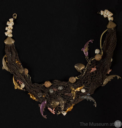 Necklace of brown net with shells, cork beads and purple, orange and bronze fish and coral shap…