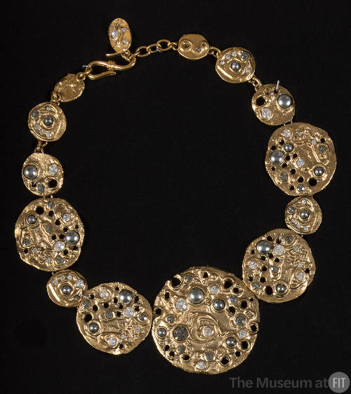 Necklace of molten gold discs of graduating size encrusted with rhinestones, iridescent stones …