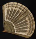 Gold metallic fan with floral design on amber frame and silk net and cream cut-out work embroid…