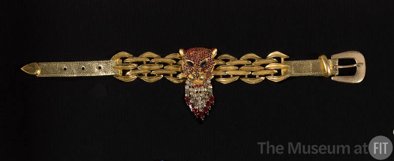 Gold choker necklace with red rhinestone panther head and clear tear drop fringe over gold link…