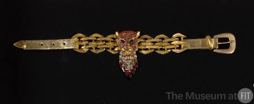 Gold choker necklace with red rhinestone panther head and clear tear drop fringe over gold link…