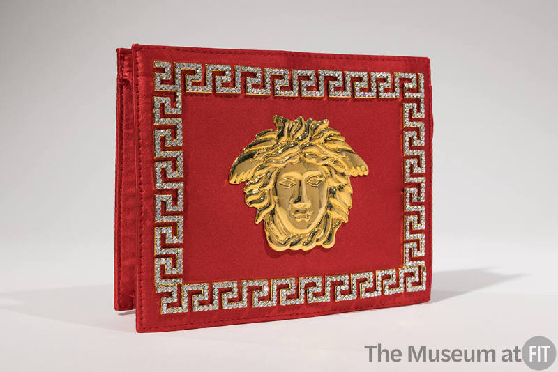 Red silk rectangular clutch evening bag with large gold Medusa ornament on center front and rhi…