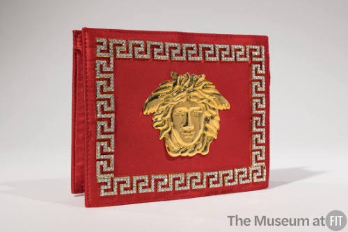 Red silk rectangular clutch evening bag with large gold Medusa ornament on center front and rhi…