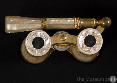 Opera glasses of mother of pearl set in a brass frame with bands of brass scroll work on the hi…