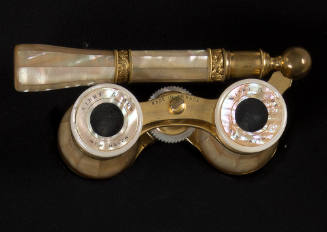 Opera glasses of mother of pearl set in a brass frame with bands of brass scroll work on the hi…