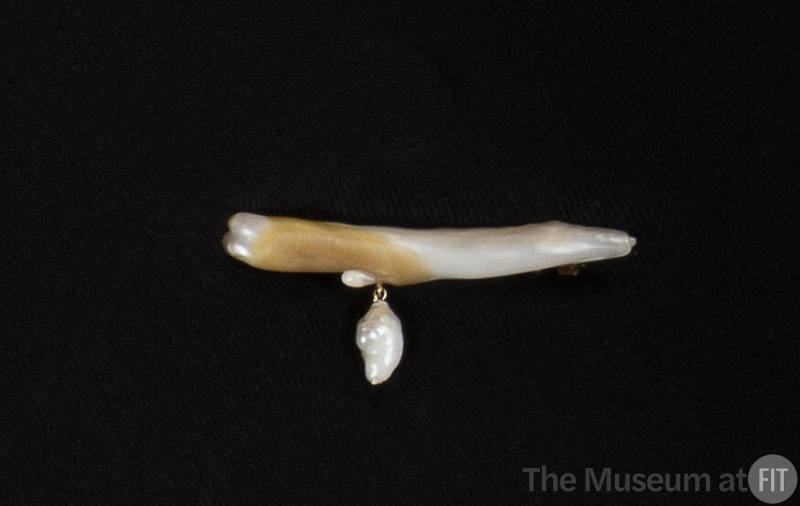 Mother of pearl pin in the shape of a branch with baroque pearl dangling left of center
