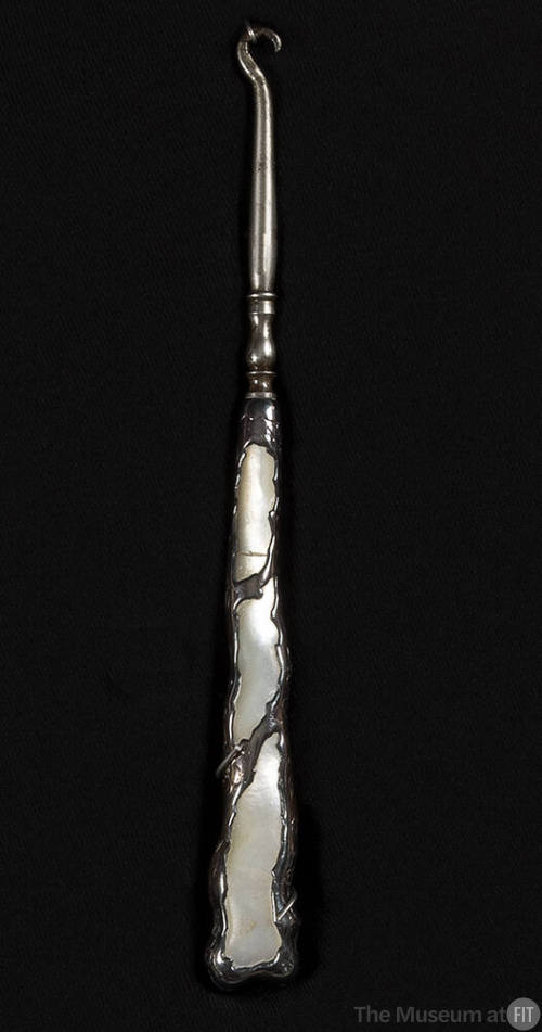 Silver buttonbook with molded design on handle of three large pearl cut outs with irregular bor…