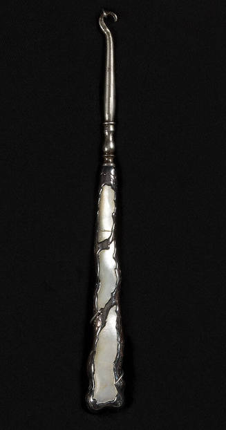 Silver buttonbook with molded design on handle of three large pearl cut outs with irregular bor…