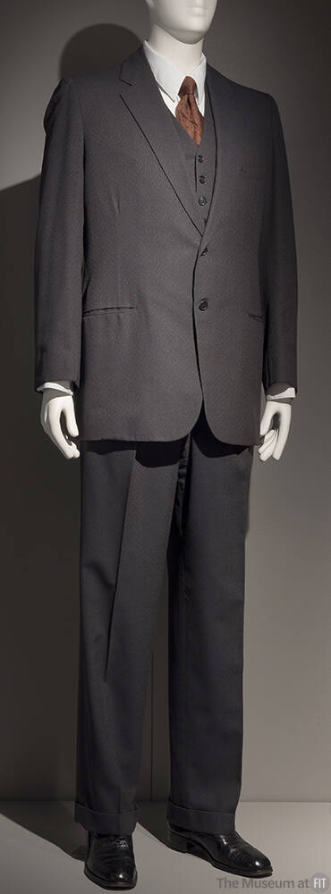 Man’s dark grey three-piece suit with single breasted jacket, vest and straight leg pants dress…