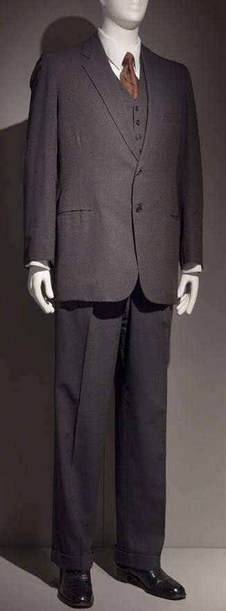 Man’s dark grey three-piece suit with single breasted jacket, vest and straight leg pants dress…