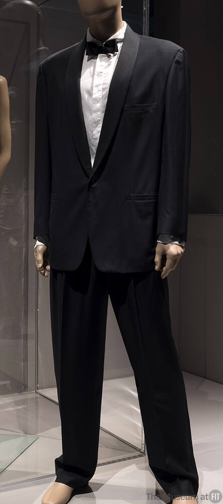 Man’s black tuxedo with satin shawl collar, tapered pants and white dress shirt dressed with bl…