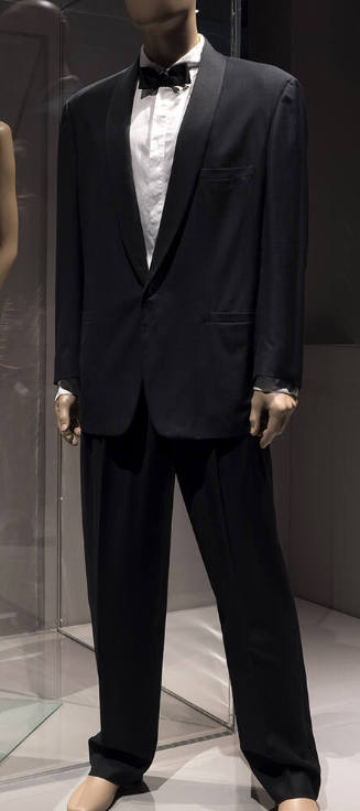 Man’s black tuxedo with satin shawl collar, tapered pants and white dress shirt dressed with bl…