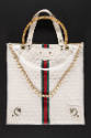 White square tote bag with double white and bamboo top handles, gold chain shoulder strap and a…