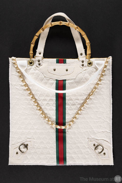 White square tote bag with double white and bamboo top handles, gold chain shoulder strap and a…