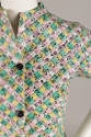 Detail view of tape measure dress showing pink, yellow, green and white interwoven tape measure…