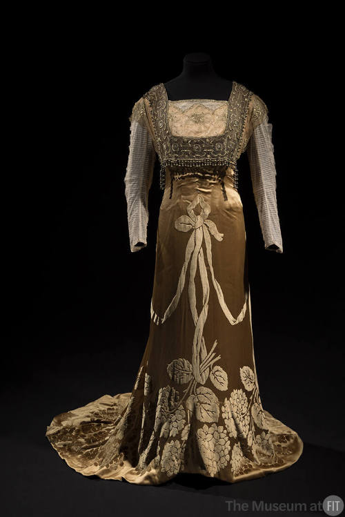 Light copper floor length dress with long net sleeves, square beaded panel over bodice and velv…