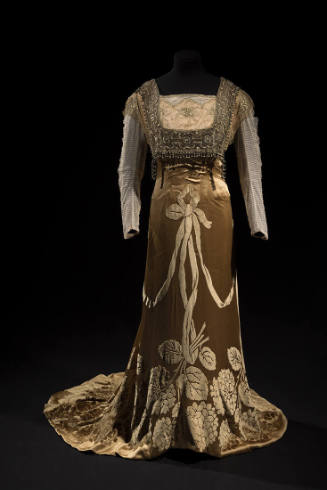 Light copper floor length dress with long net sleeves, square beaded panel over bodice and velv…