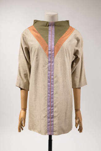 Beige ¾ sleeve tunic top with funnel neck trimmed with a green triangle outlined in orange and …
