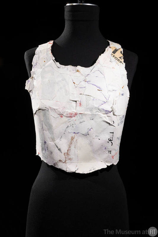 Sleeveless scoop neck bustier made of molded white cardboard with traces of print writing and f…