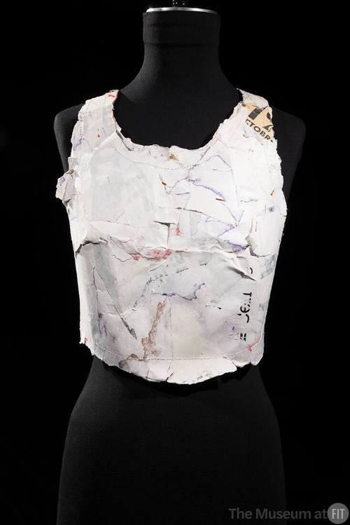 Sleeveless scoop neck bustier made of molded white cardboard with traces of print writing and f…