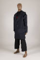 Man’s ensemble of navy blue deconstructed coat with detached sleeve over black sweater and crop…