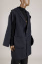 ¾ view of man’s ensemble of navy blue jacket with partially detached sleeve and outside patch p…