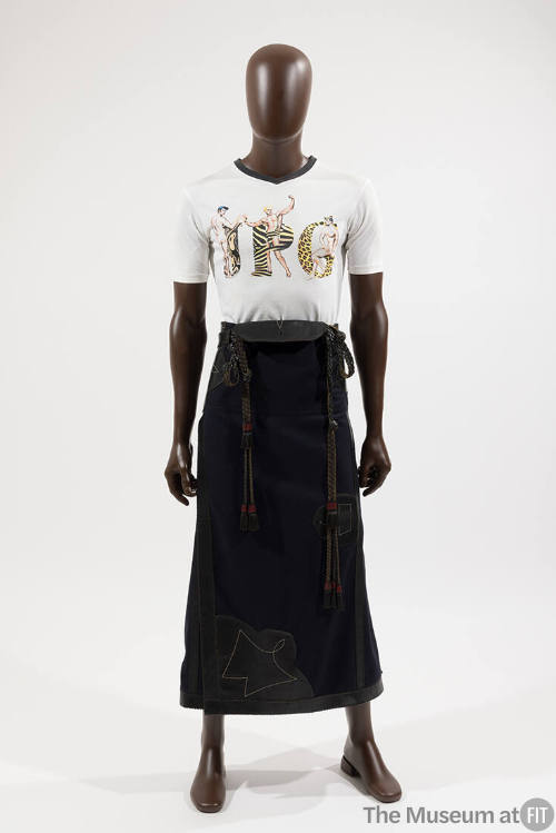 Man’s white short sleeve t-shirt with animal print JPG and three male figures and navy blue ank…