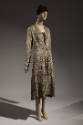 Gold and black brocade evening coat with allover Oriental style patterns and gold braid trim dr…