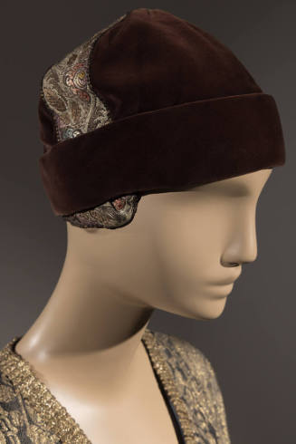 Brown velvet cloche hat with wide cuff brim and gold brocade ribbon trim across top from ear to…