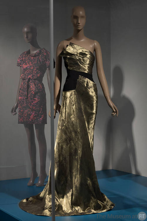 Gold strapless floor length pooling evening dress with asymmetrical bodice and draped skirt pan…
