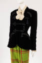 ¾ view of ensemble showing black velvet jacket with fitted waist and curved hip pockets over cr…
