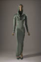 Green ankle length long sleeve sheath dress with hood, cowl neck and seams across forearms and …
