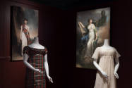 Art X Fashion exhibition installation view of two mannequins in a plaid and white dress in fron…