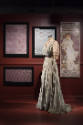 Art X Fashion exhibition installation view of a mannequin in a dress in front of an image of a …