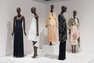 Art X Fashion exhibition installation view of five mannequins in dresses on a white platform