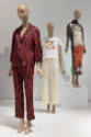 Art X Fashion exhibition installation view of three mannequins in red pajamas, a t-shirt ensemb…