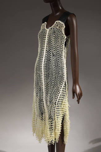 Off-white 3D-printed dress; plastic circular links crocheted with cotton, wide black leather sh…
