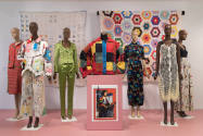 Beyond Utility exhibition installation view of seven dressed mannequins and a podium with a pho…