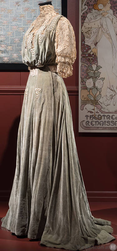 Light green velvet floor length dress with high ivory lace collar, yoke and puffed elbow length…