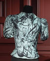 Turquoise blouse with black abstract pattern of lines and dots, band collar, short sleeves and …
